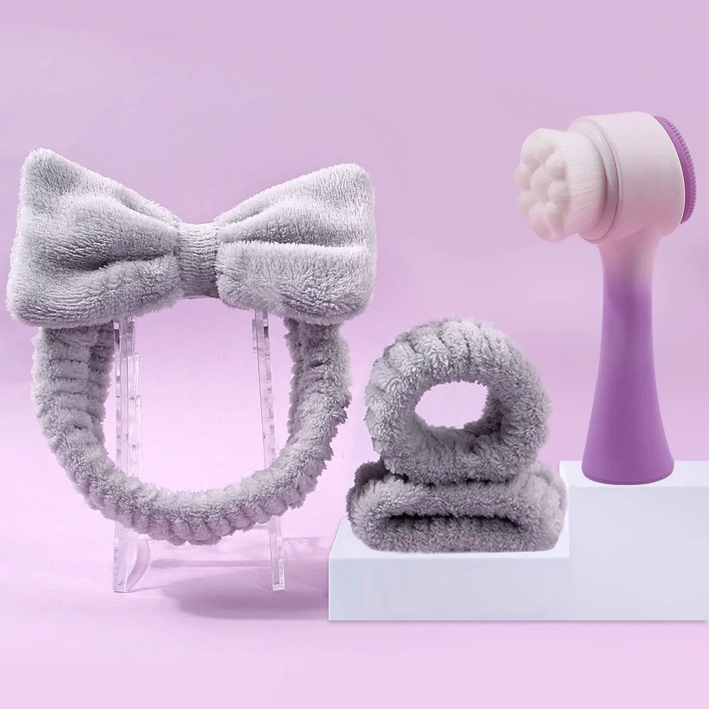 Facial brush with plastic handle and nylon bristles alongside coral fleece absorbent hair band in purple colour