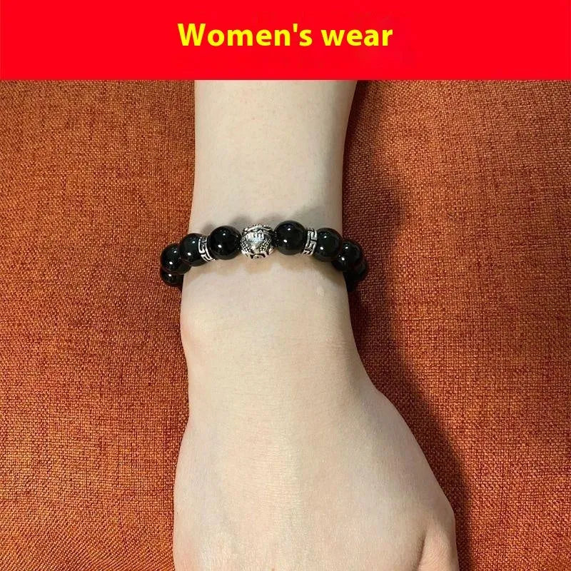 Natural obsidian bead bracelet with Silver 999 details and Cloud Year Of design on a wrist.