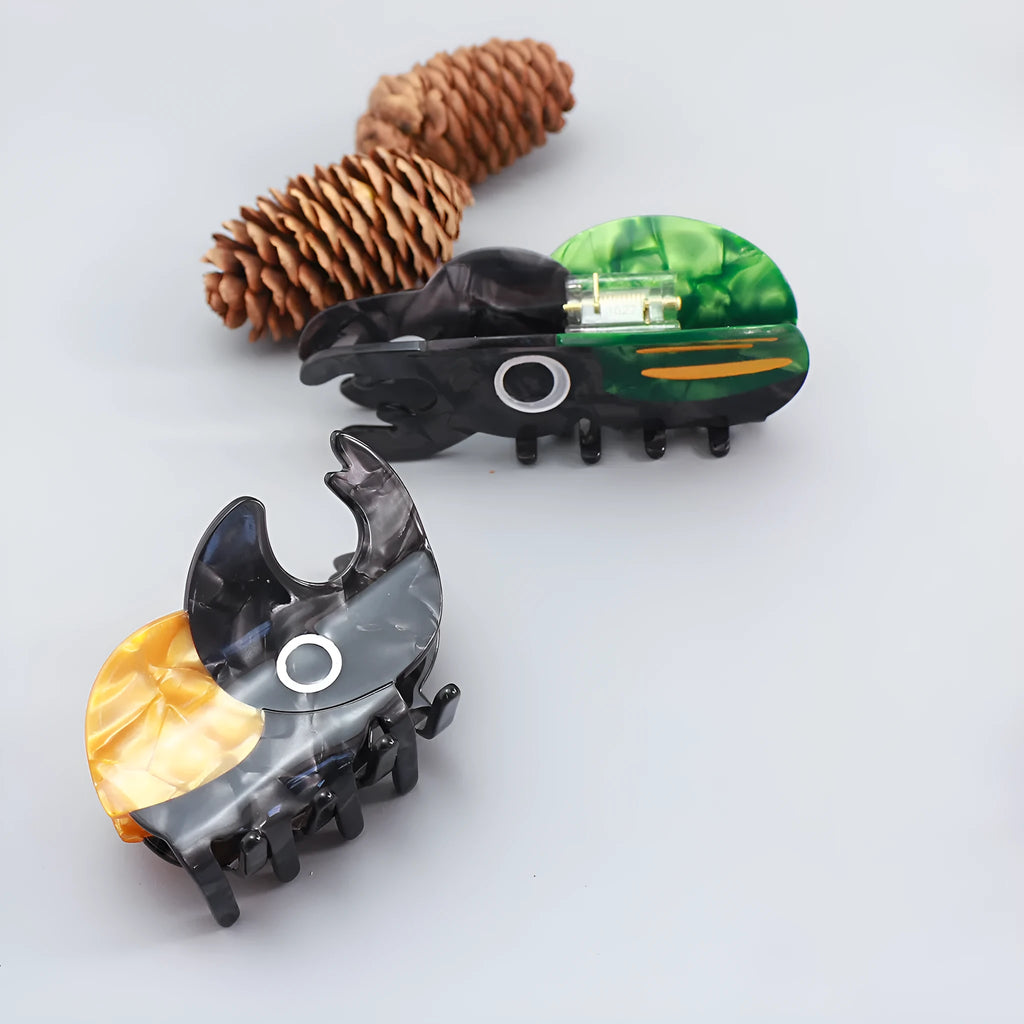 Handmade cellulose acetate insect grip with green beetle, orange beetle, and white caterpillar models for biology study.