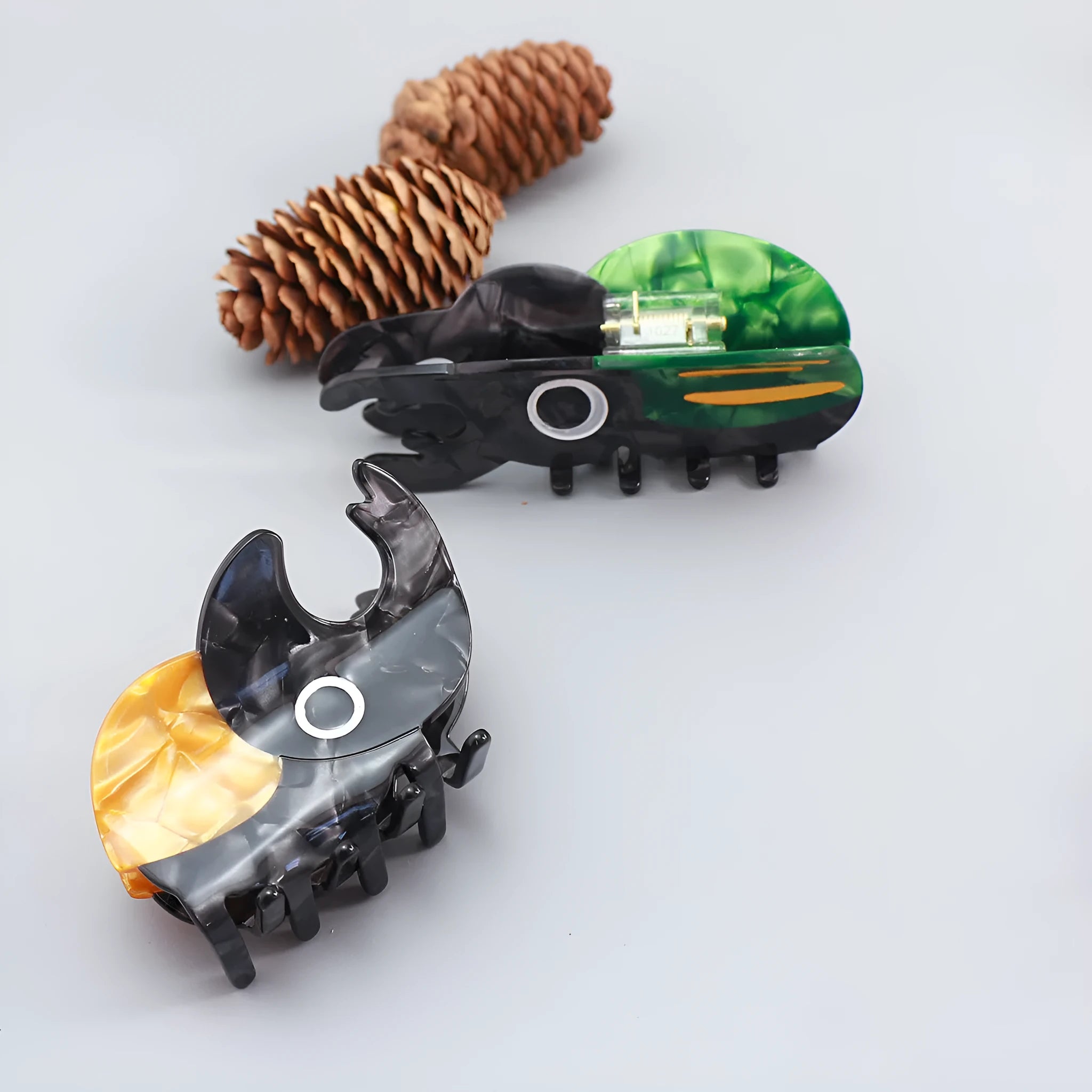 Handmade cellulose acetate insect grip with green beetle, orange beetle, and white caterpillar models for biology study.