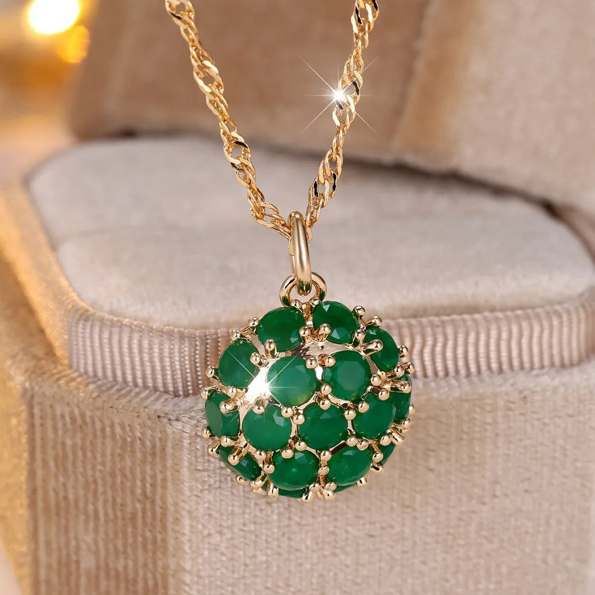 Geometric copper pendant necklace with round emerald and diamonds on an adjustable chain in champagne gold.
