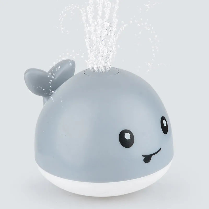 Automatic water spray whale bath toy floating in water with fountain and LED lights