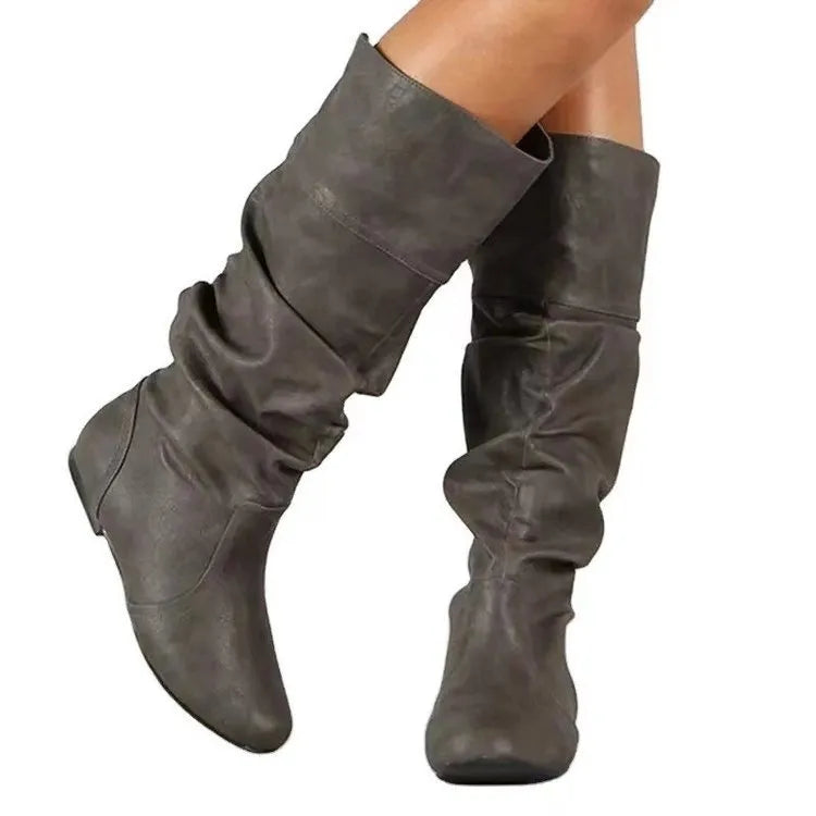 Women's flat ankle boots in black with a round toe and slip-on design on a rubber sole.