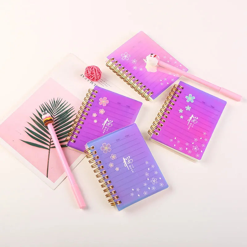 Set of four A7 spiral-bound pocket notebooks with different coloured PP covers showing Constellation, Sakura, Ocean, and Universe designs.