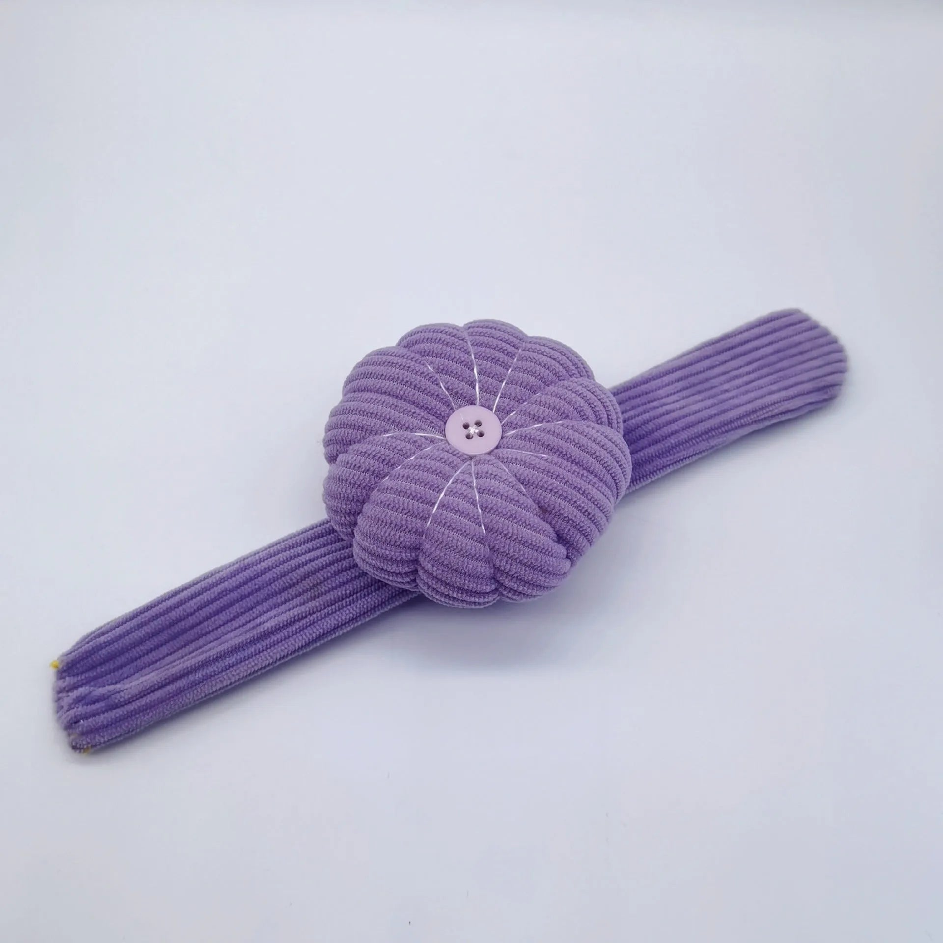 Ring pincushion sewing tool with vertical cutting slot in caramel colour showing fabric cushion and metal ring base