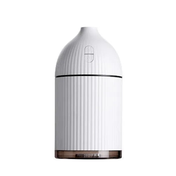 White ultrasonic aromatherapy diffuser with LED light and USB cable on a wooden table