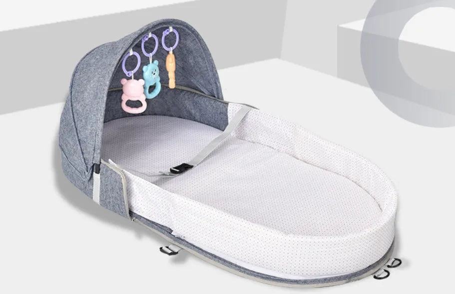 Portable foldable baby anti-mosquito isolation bed with grey cotton linen fabric, open on a grassy area