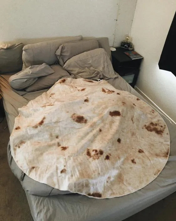 Round coral fleece flannel blanket rolled in a burrito style, showing soft texture and printed design.
