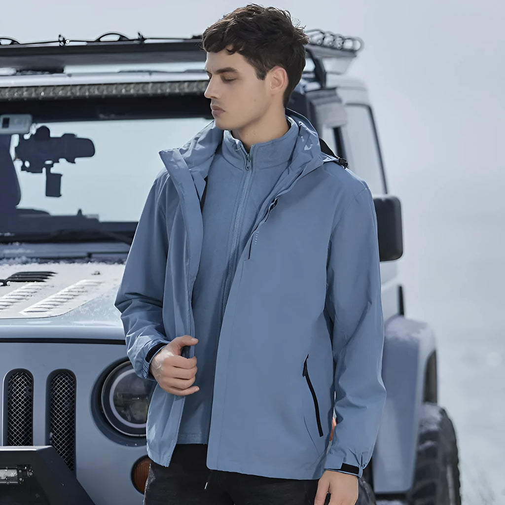 Man wearing a fluorescent coloured waterproof mountaineering suit with a cardigan-style jacket for outdoor sports.