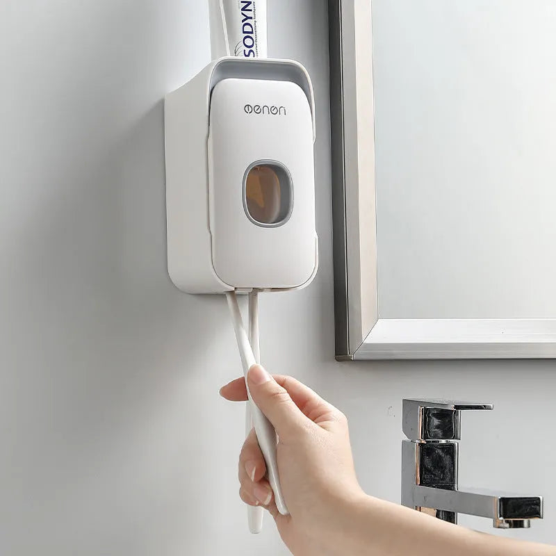 Blue automatic toothpaste dispenser made of ABS plastic on a bathroom shelf.