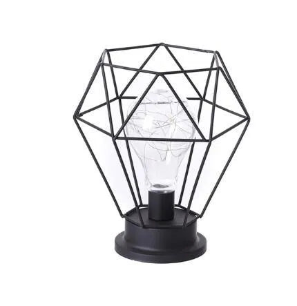 Minimalist hollow iron table lamp in red wine glass style on a wooden desk.