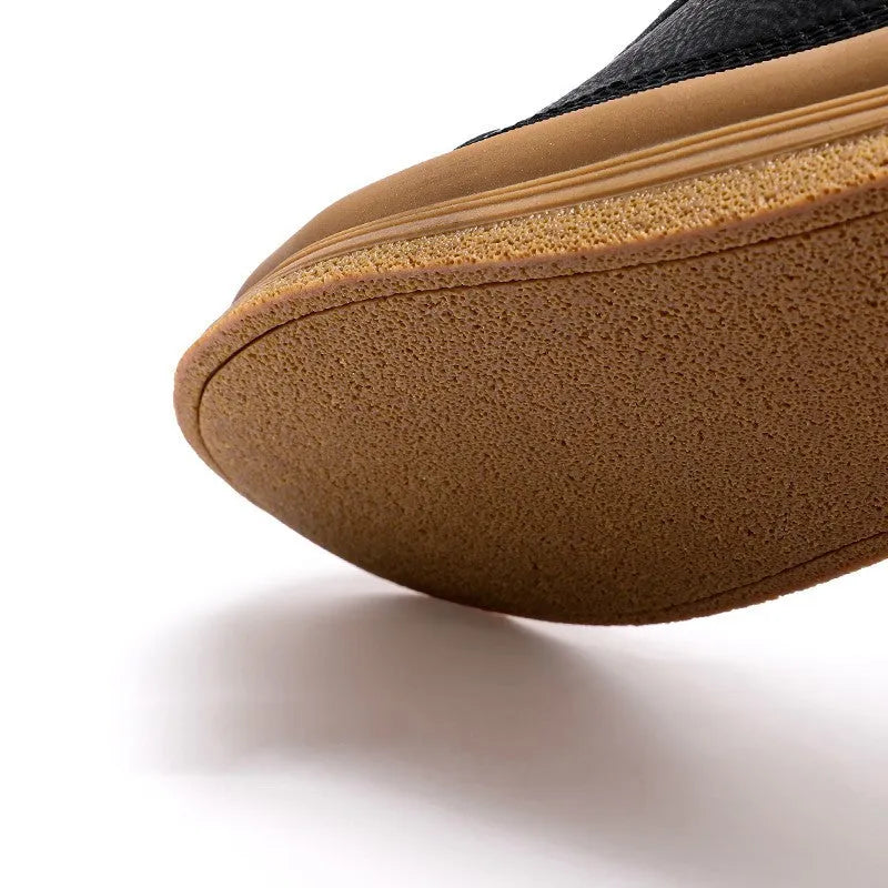 Men's black casual leather shoes with a round toe and white rubber sole on a plain background.