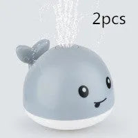 Automatic water spray whale bath toy floating in water with fountain and LED lights