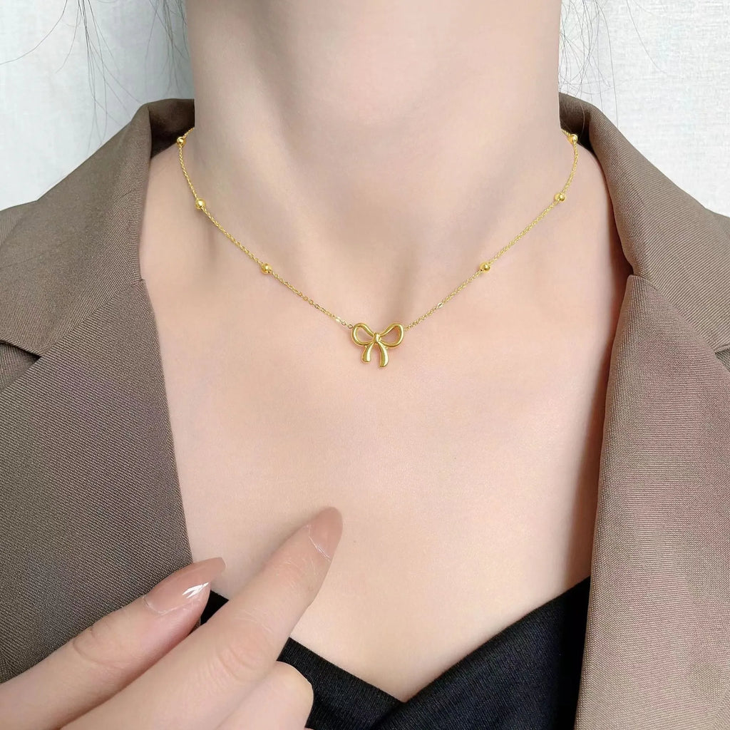 Gold electroplated bow necklace with cross chain design on adjustable 41-50cm chain