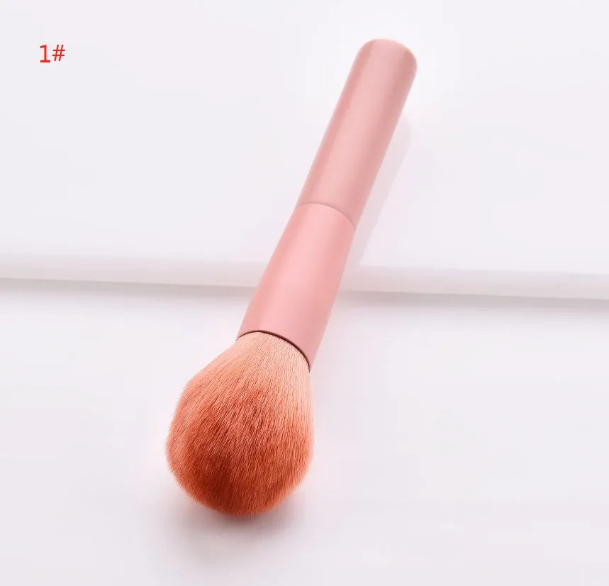 Ten makeup brushes with wooden handles arranged showing different brush head types including powder, foundation and double-headed tools