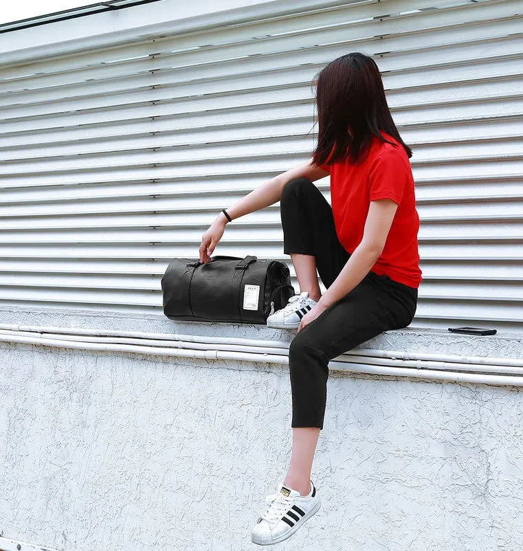 Black waterproof sports fitness bag with separate shoe compartments and diagonal carry straps.