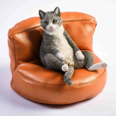 Small lazy cat car ornament and sofa, 7.5cm tall resin model on a car dashboard.