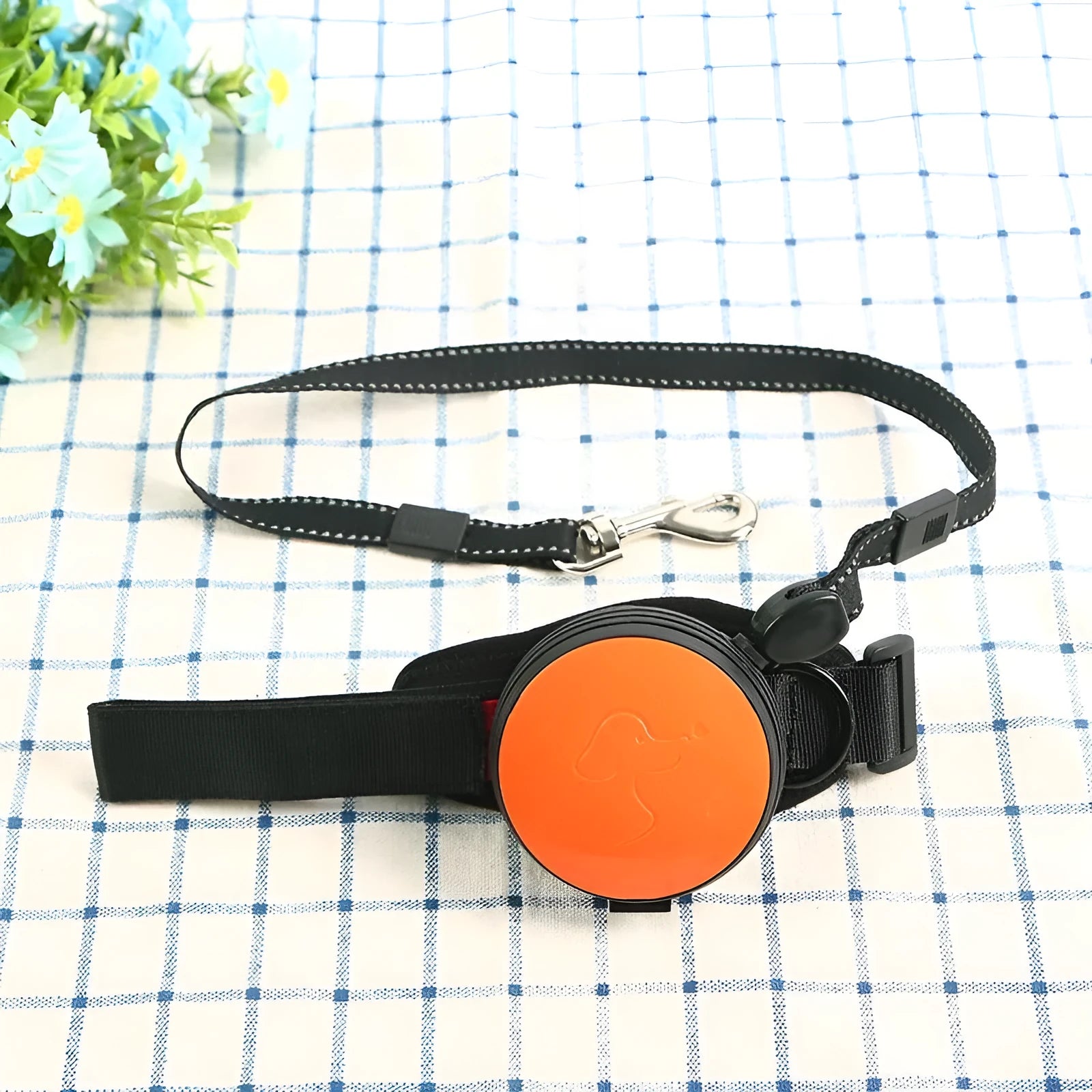 Automatic retractable dog leash extended to 3 metres, shown in vibrant orange colour with ergonomic handle.