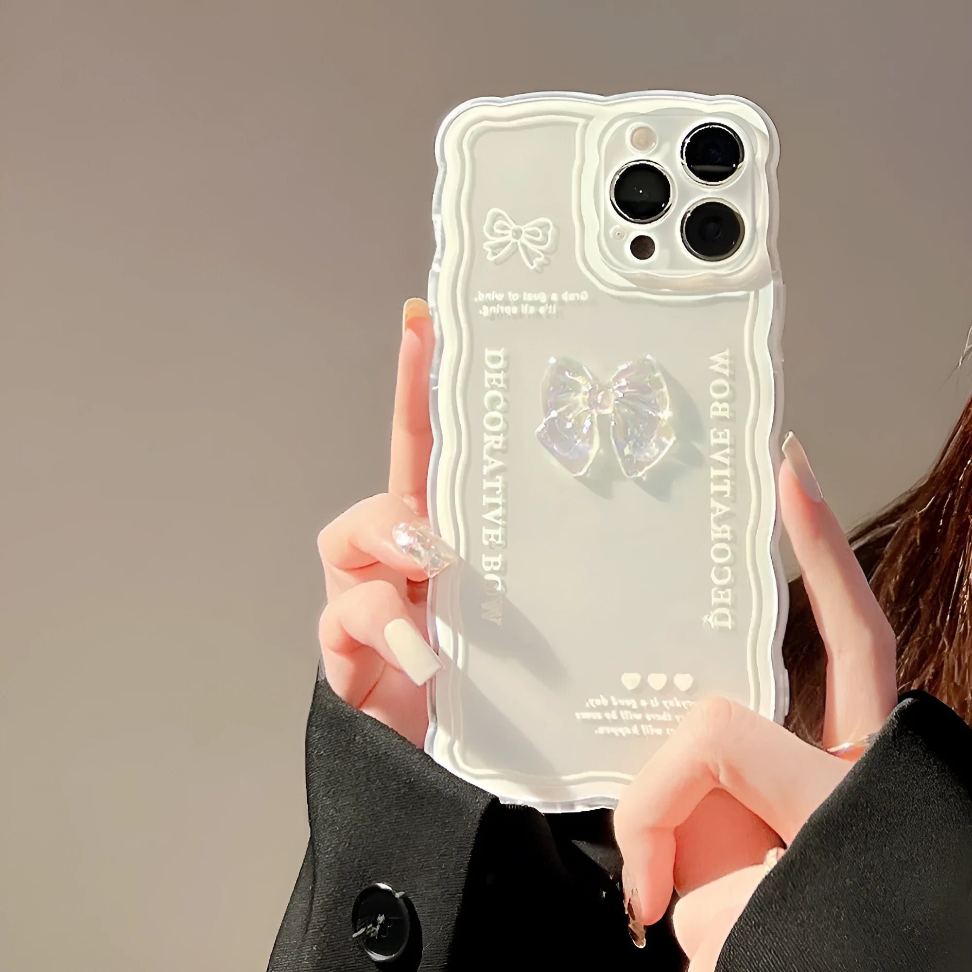 Clear transparent iPhone case with a raised 3D ice-effect bow design on the back.