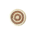 Round natural papyrus placemat with tassel trim on a wooden table.