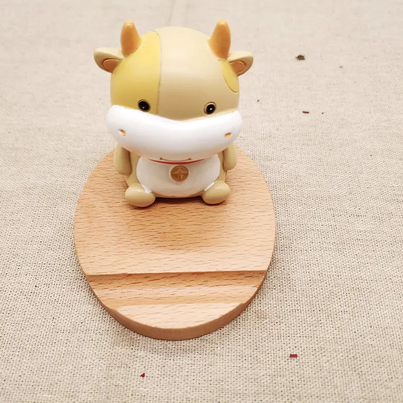 Beech wood mobile phone holder stand with coin slot and decorative carving.