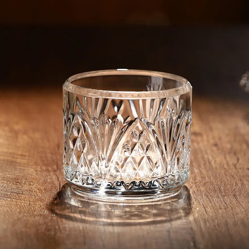 Stackable engraved glass wine glasses and sake barrel on a table