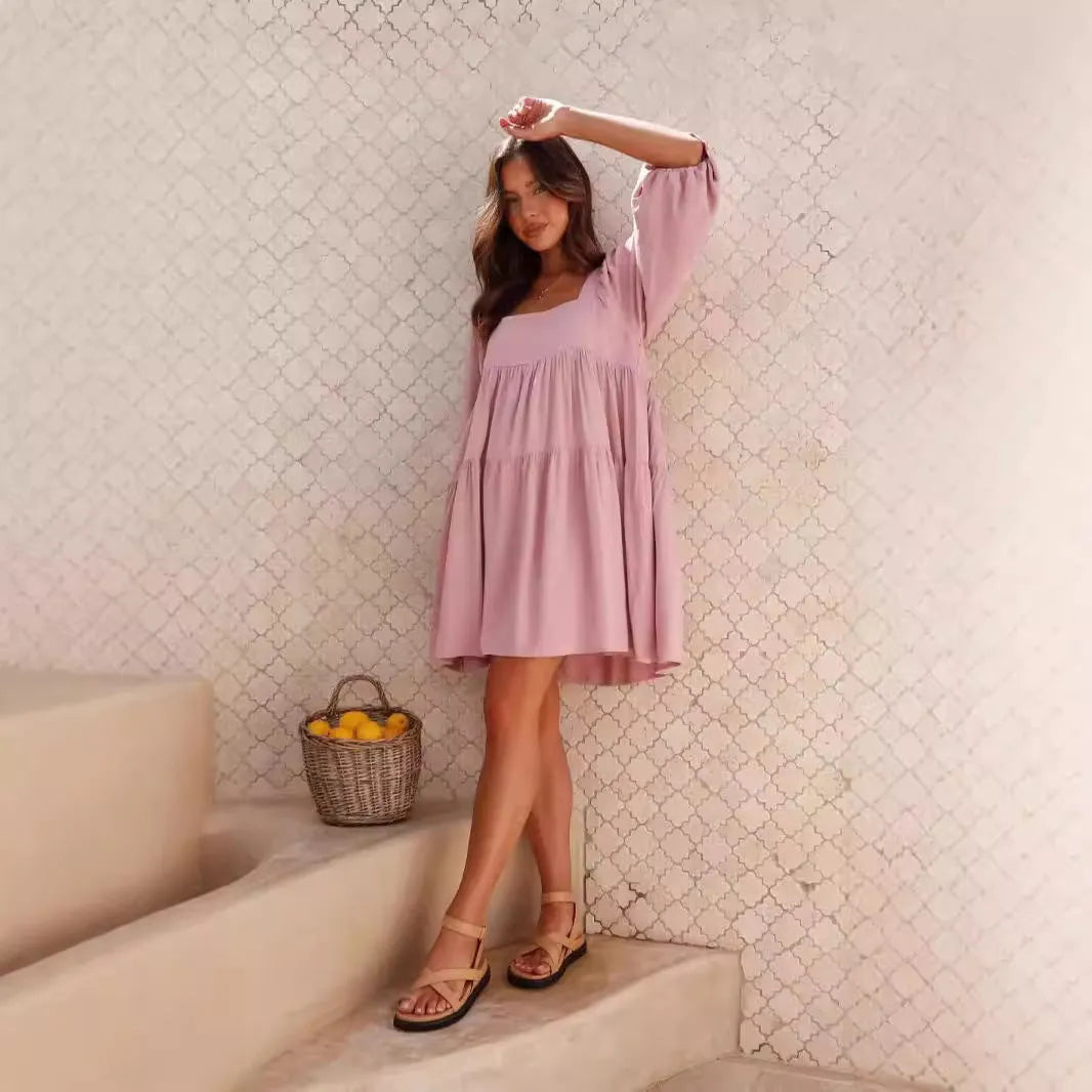 Light blue children's backless dress with puff sleeves, a square collar, and an A-line skirt on a hanger.