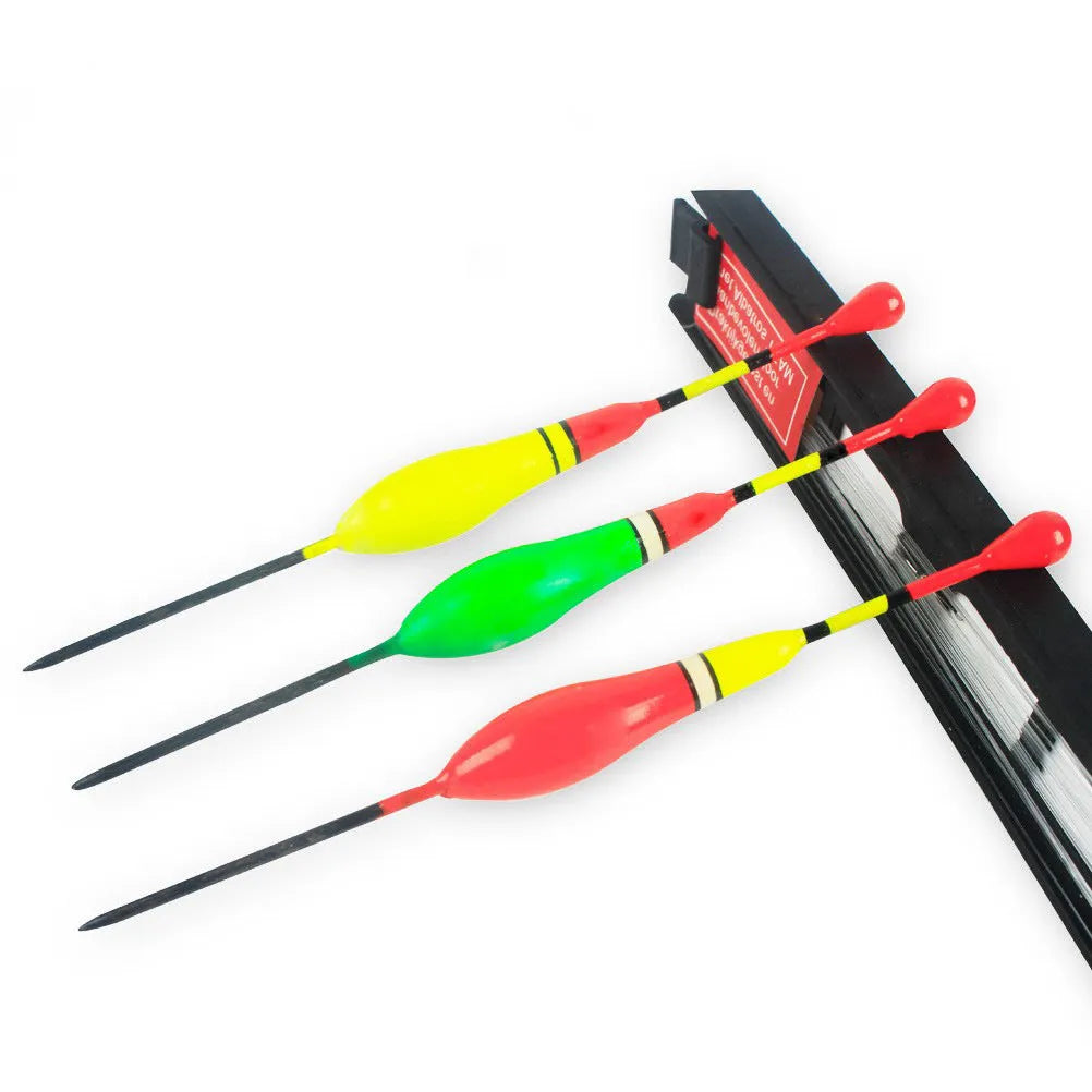 Three plastic vertical fishing floats with wire group and double hook on a dark background
