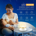 White touch-control bedside night light with motion sensor and rechargeable battery on a table.
