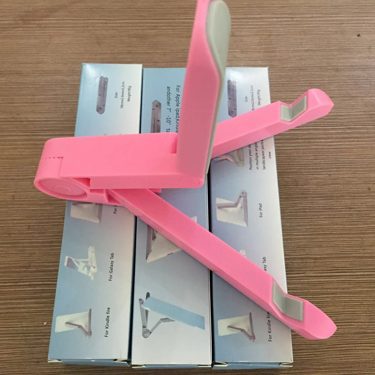 Black foldable aluminium tablet holder open in landscape mode supporting an iPad, showing side adjustment buttons.