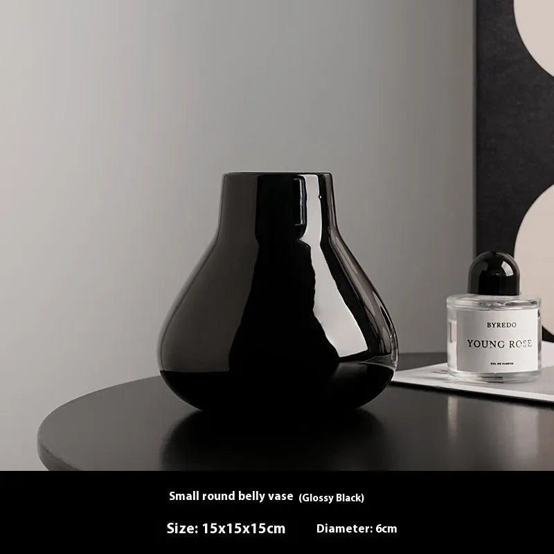 Ceramic decorative vase with coloured glaze surface and artificial orchid flowers in black or white colour