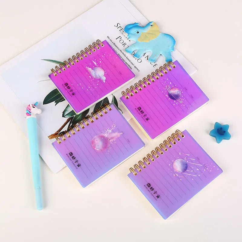 Set of four A7 spiral-bound pocket notebooks with different coloured PP covers showing Constellation, Sakura, Ocean, and Universe designs.