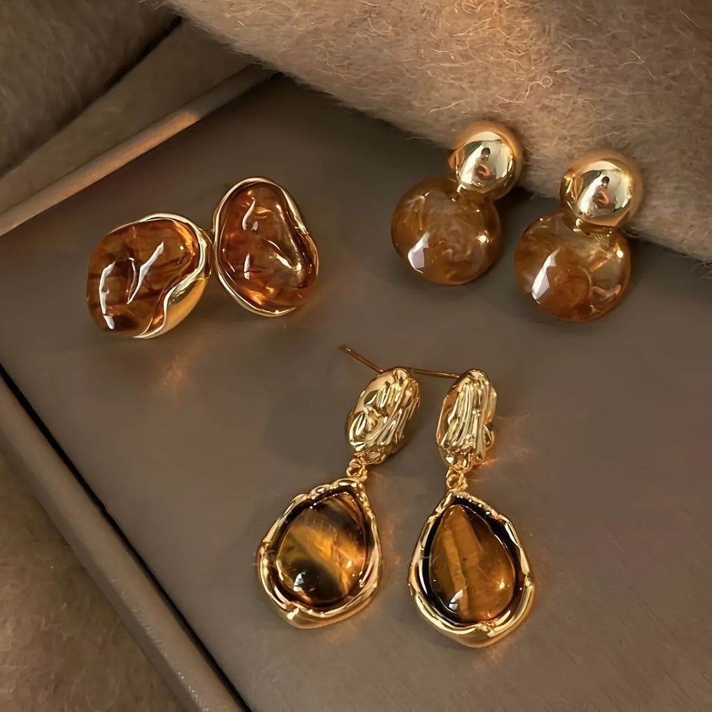Three pairs of handmade geometric ear studs with electroplated alloy construction and tassel detailing in different colour treatments
