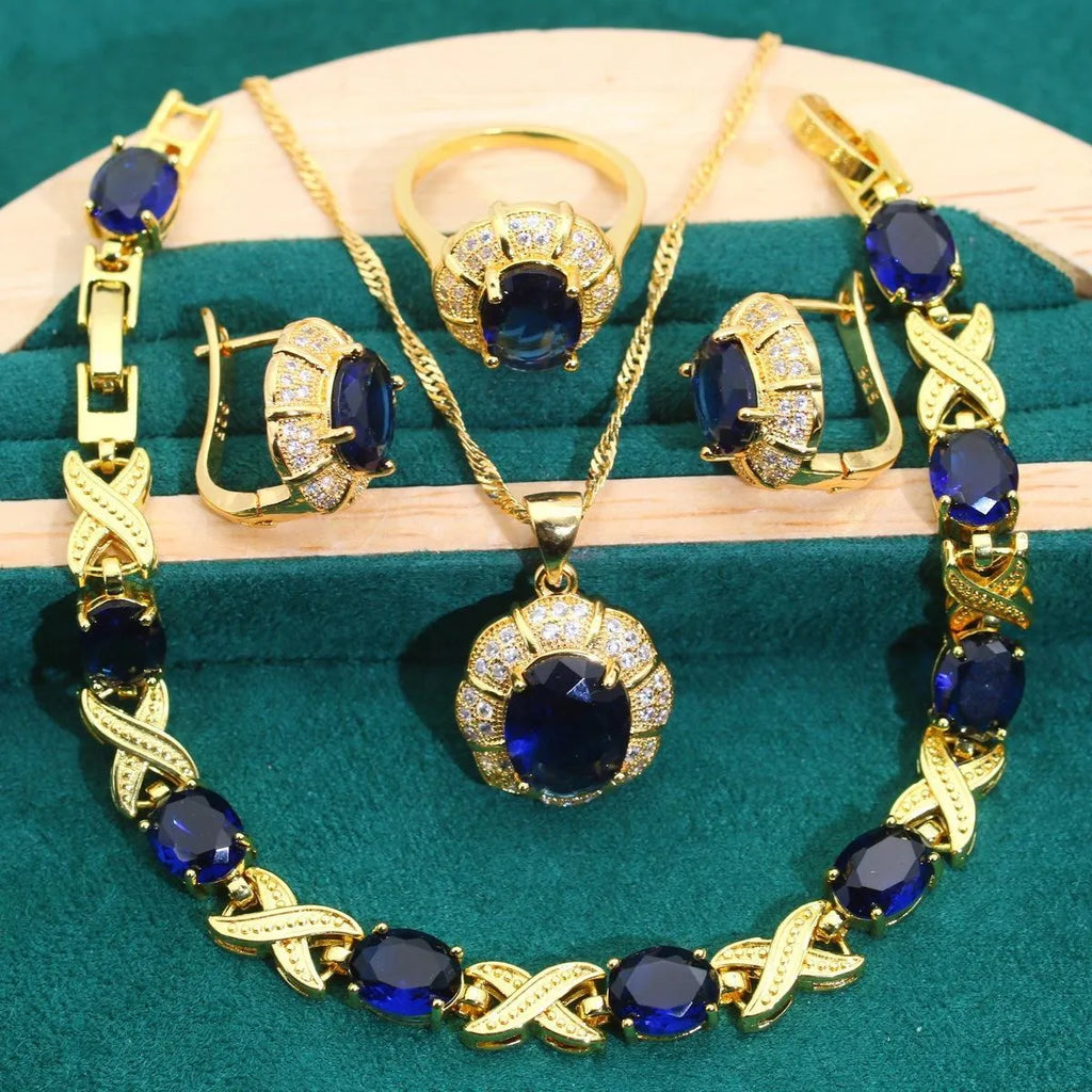 Gold plated jewellery set with colourful cubic zirconia stones, showing ring, earrings, bracelet, and necklace.