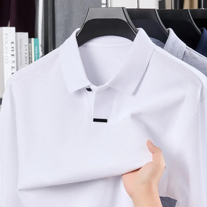 Man wearing a loose grey cotton polo shirt with a lapel collar and asymmetric design detail.