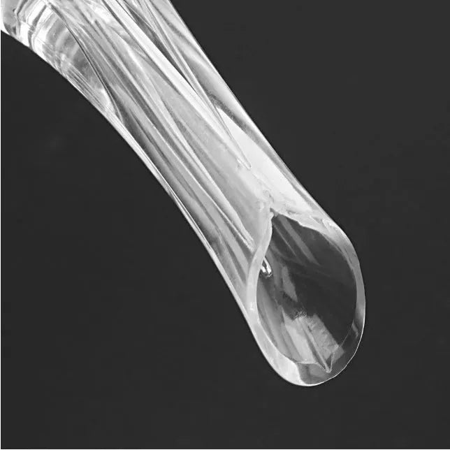 A slender, clear acrylic wine aerator pourer with a stainless steel filter inside, shown next to a wine glass.
