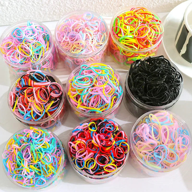 Multi-colour TPU baby hair ties for toddlers stored in a reusable clear container.