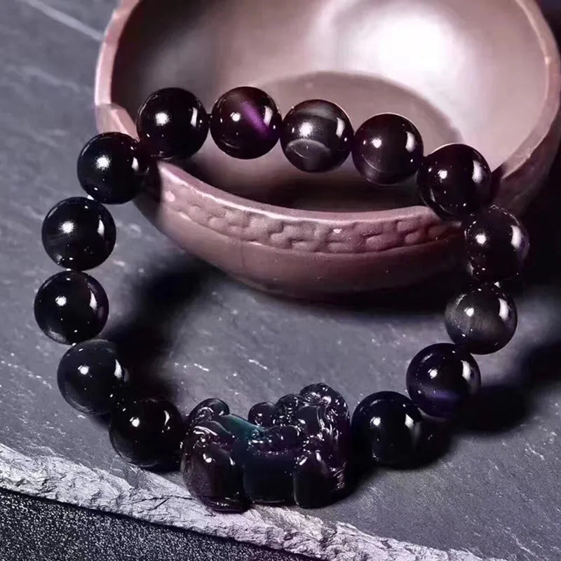 Natural ice colour Eye Obsidian crystal beaded bracelet on a wrist, showing round beads.