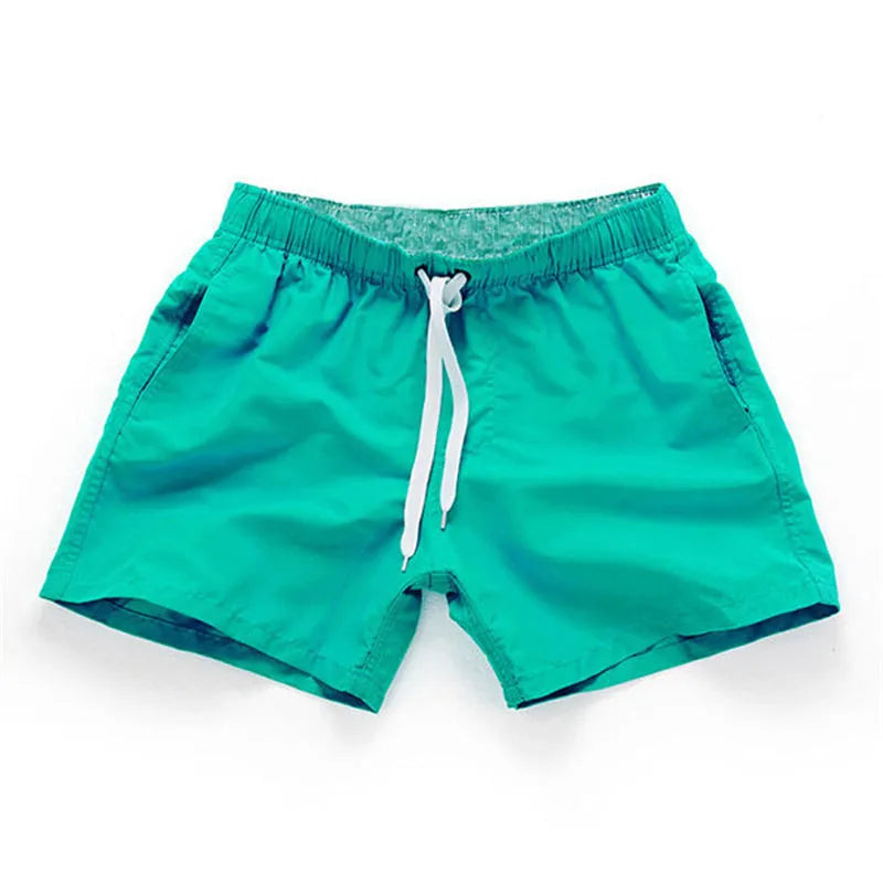 Men's straight-leg beach shorts in polyester, shown in a colour from the range including fluorescent yellow, black, or navy.