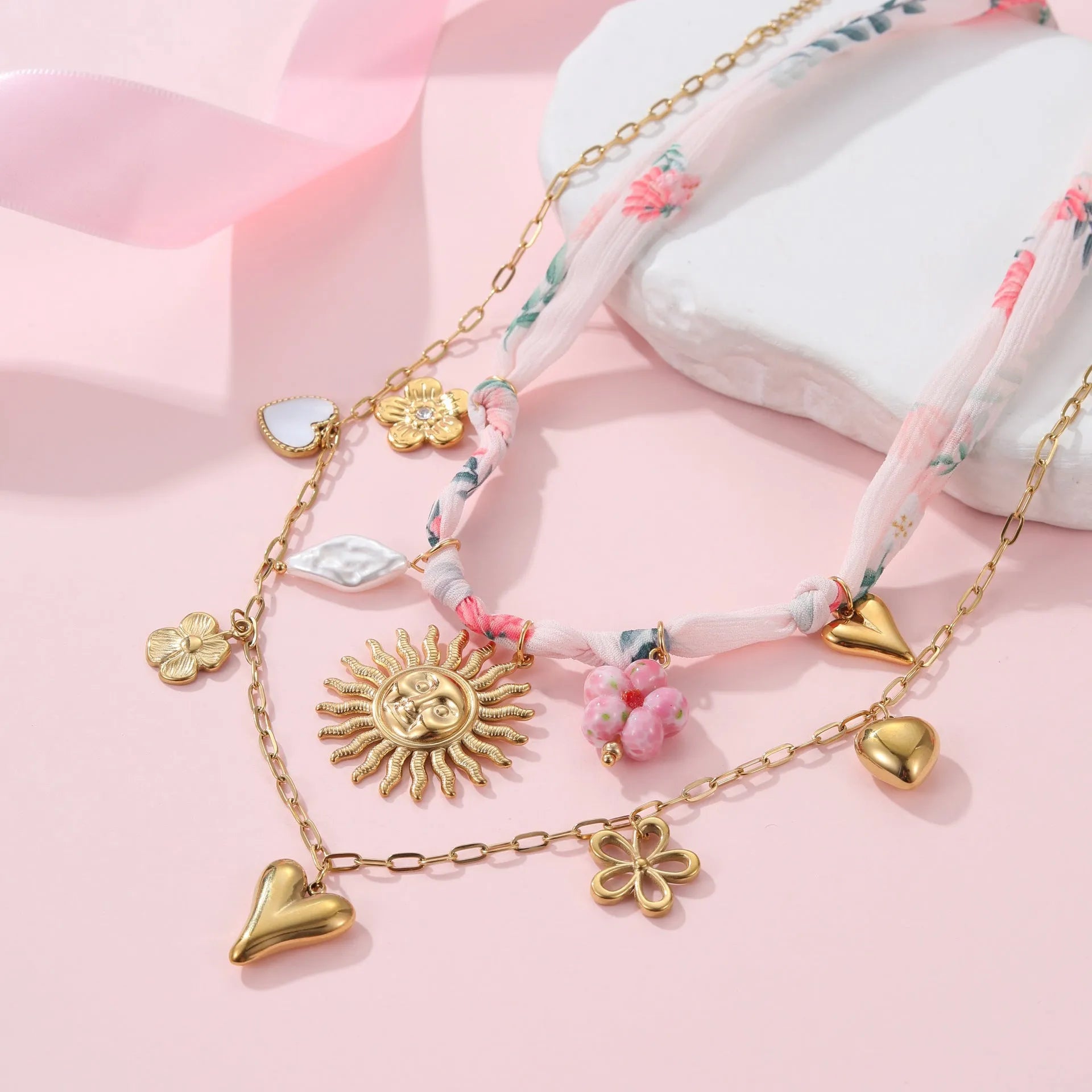 Stainless steel necklace with geometric sun pendant and gold electroplated finish on adjustable chain