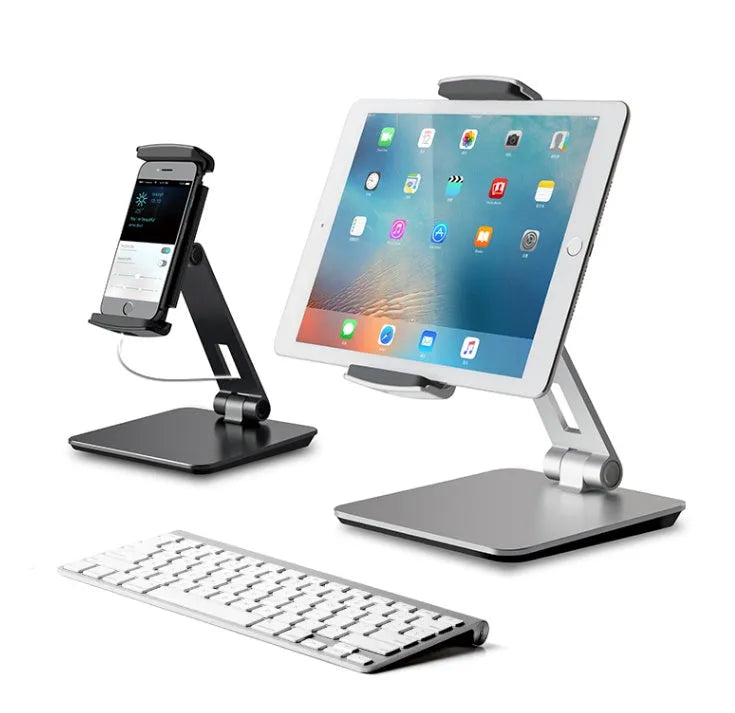 Folding aluminium desktop phone and tablet stand with 360-degree rotation on a wooden desk.