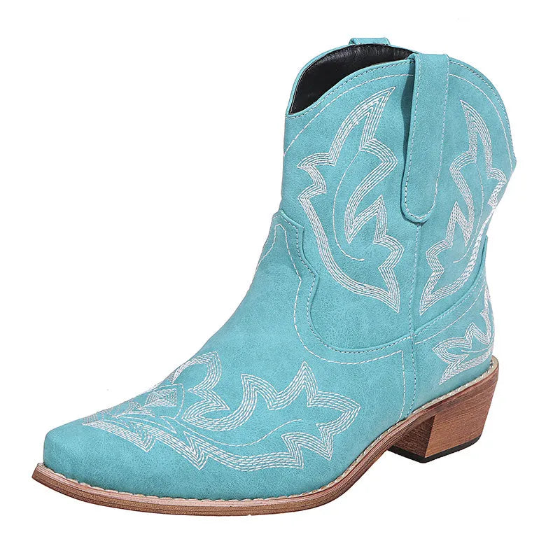 Blue women's cowboy boots with embroidery and a low wedge heel on a wooden floor.
