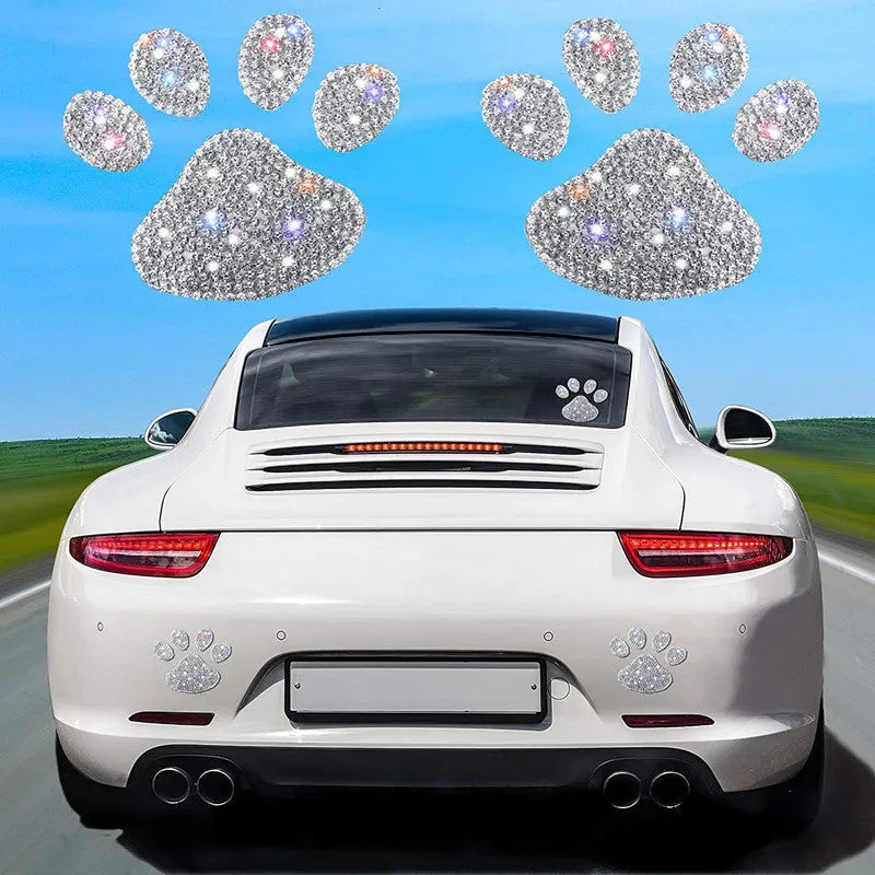 Close-up of a diamond-sparkle glass car sticker in a butterfly or bear paw design on a car surface.