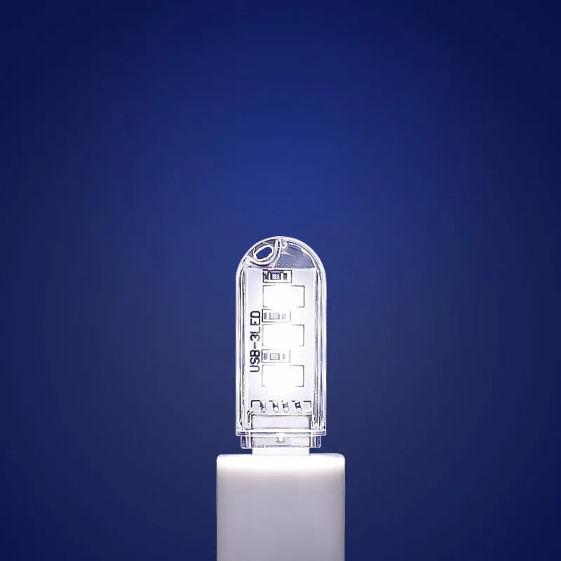 Small white USB-powered baby night light showing warm and white light options on a table