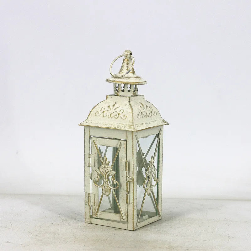 Black wrought iron floor lantern with glass panels on a stone patio.