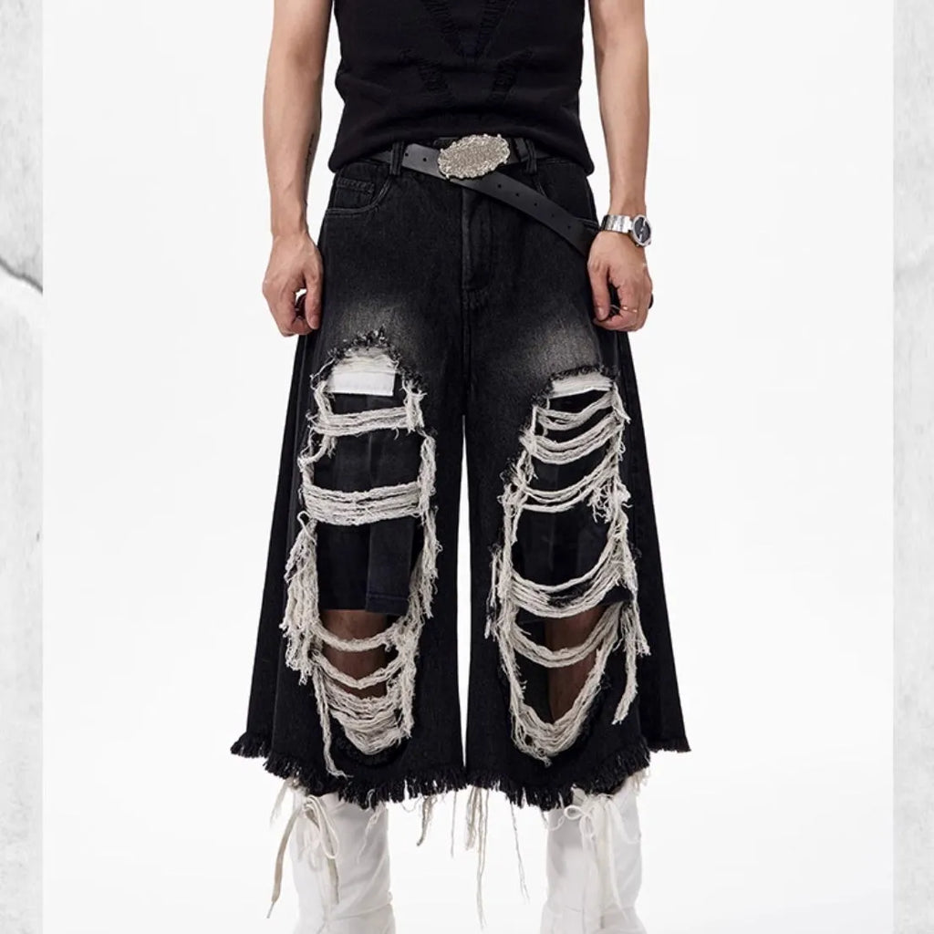 Black women's wide-leg cropped jeans with ripped patch details on the legs.