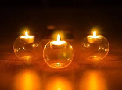 Clear round hollow glass candle holder for a tea light on a table