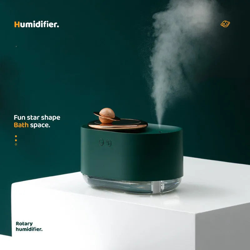 Green rotating planet USB portable humidifier with night light on a wooden desk.