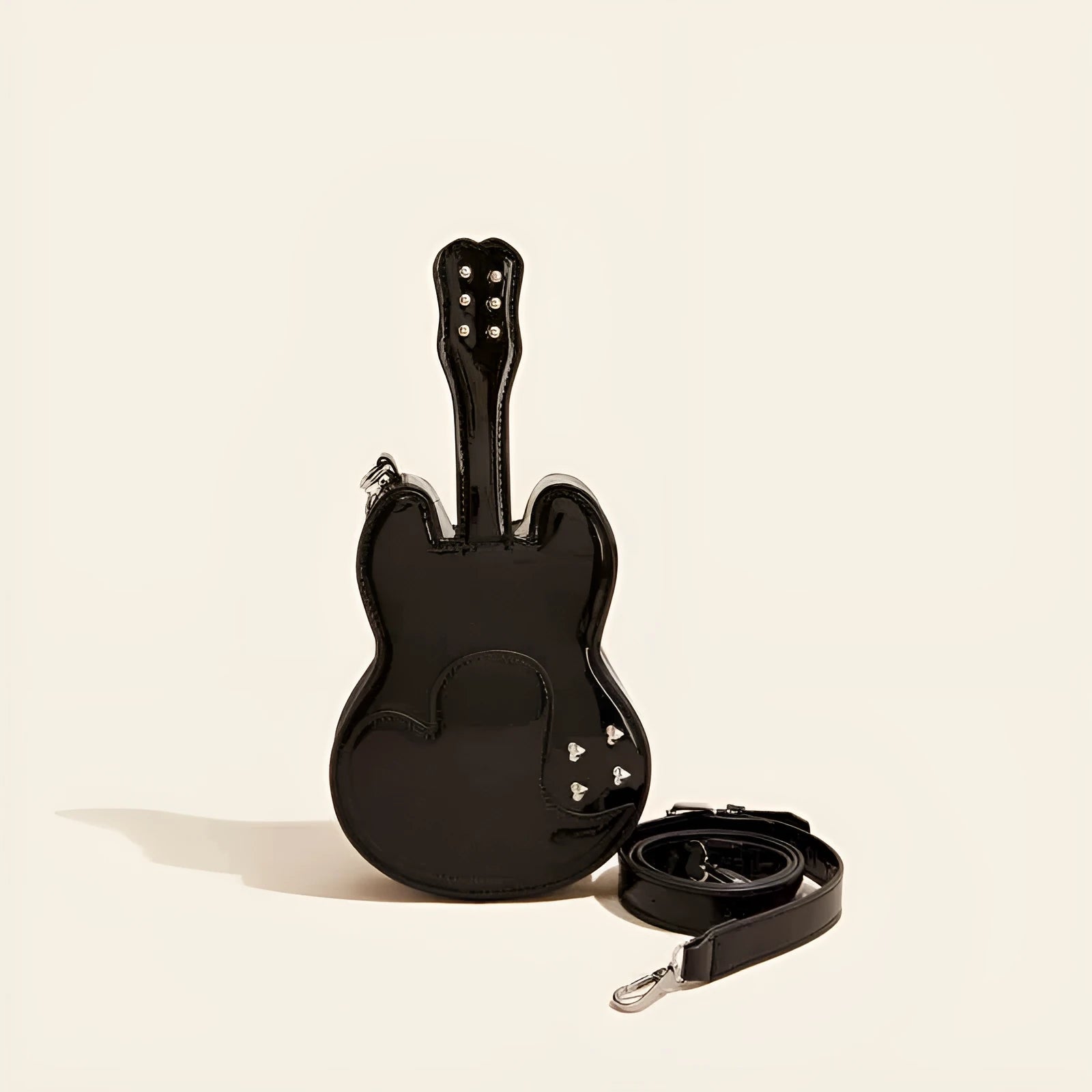 PU leather guitar-shaped crossbody bag in silver, shown with phone and wallet inside.