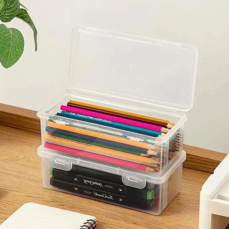 Transparent plastic stationery storage box containing pencils and colour crayons